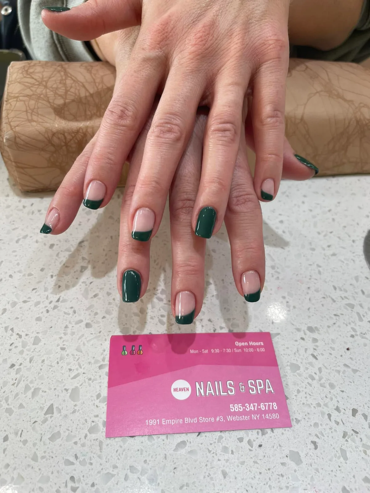 Dark green French tips on short square nails, two painted solid