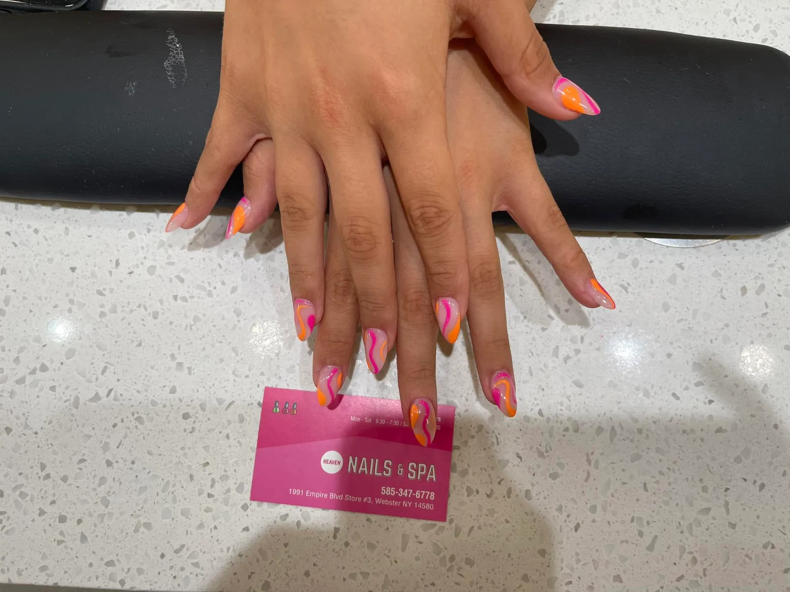 Orange and pink swirl designs on almond nails